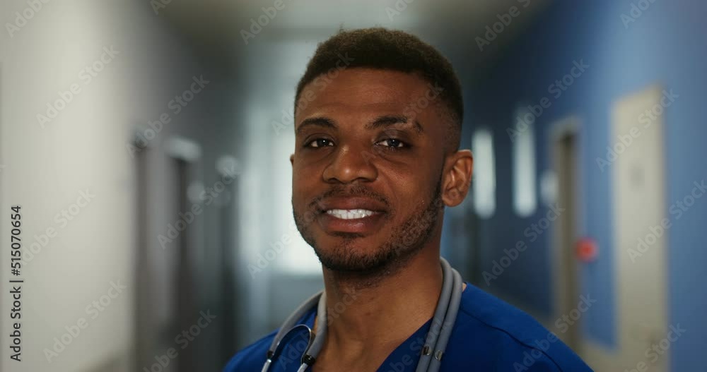 African American doctor looks into the camera standing in a corridor of clinic African American doctor looks into the camera standing in a corridor of clinic