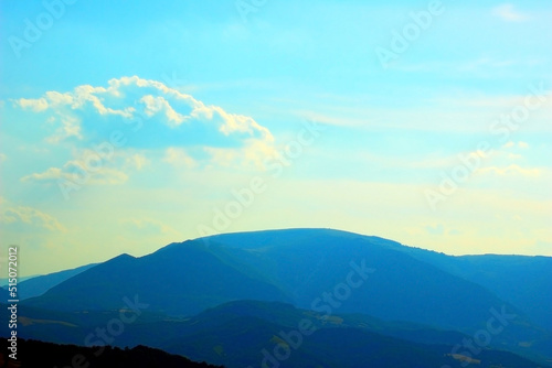 Outlook over a foggy ridge of the Sibillini mountains with deep blue colors and the beautiful sky on a great summer day
