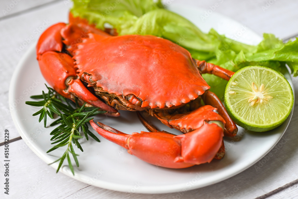 seafood plate with herbs spices rosemary lemon lime salad lettuce vegetable, fresh crab on white plate, crab cooking food boiled or steamed crab red in the restaurant seafood plate with herbs spices rosemary lemon lime salad lettuce vegetable, fresh crab on white plate, crab cooking food boiled or steamed crab red in the restaurant
