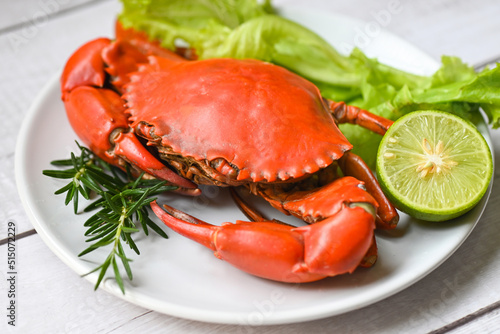 seafood plate with herbs spices rosemary lemon lime salad lettuce vegetable, fresh crab on white plate, crab cooking food boiled or steamed crab red in the restaurant