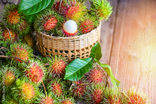 Fresh and ripe rambutan sweet tropical fruit peeled rambutan with leaf, Rambutan fruit on basket background harvest from the garden rambutan tree photo