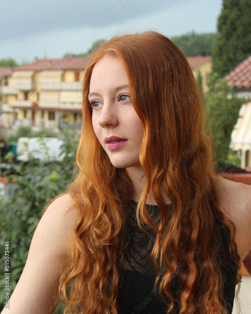 3/4 portrait of a beautiful young woman with blue eyes and long red ...