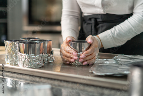 young girl chef makes desserts. bakes sweets and cakes. makes blanks and prepares fruits for the filling. baking, dessert, sweets, complex cooking processes.