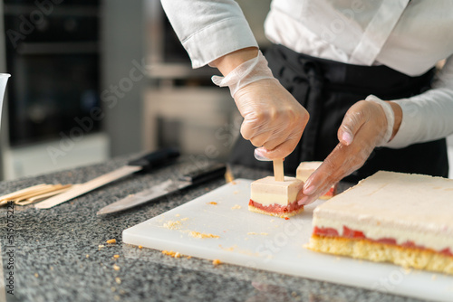 young girl chef makes desserts. bakes sweets and cakes. makes blanks and prepares fruits for the filling. baking, dessert, sweets, complex cooking processes.