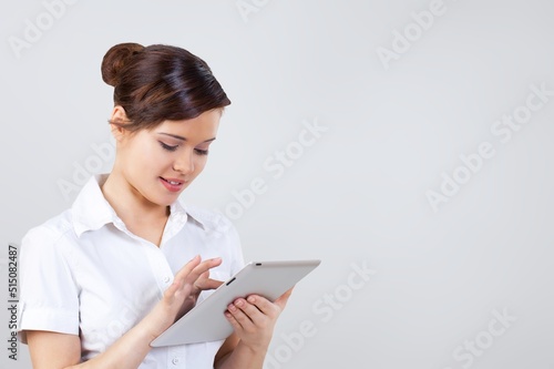 Portrait of cheerful charming girl hold tablet posing on the background