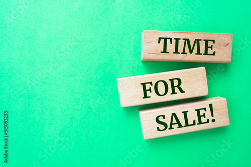 Time for sale words on wooden blocks on green background.