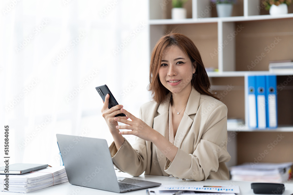 Asian businesswoman in formal suit in office happy and cheerful during using smartphone and working. Asian businesswoman in formal suit in office happy and cheerful during using smartphone and working.