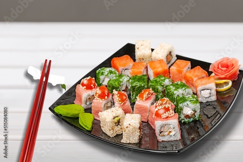 Tray sushi salmon varieties for delivery on a desk background.