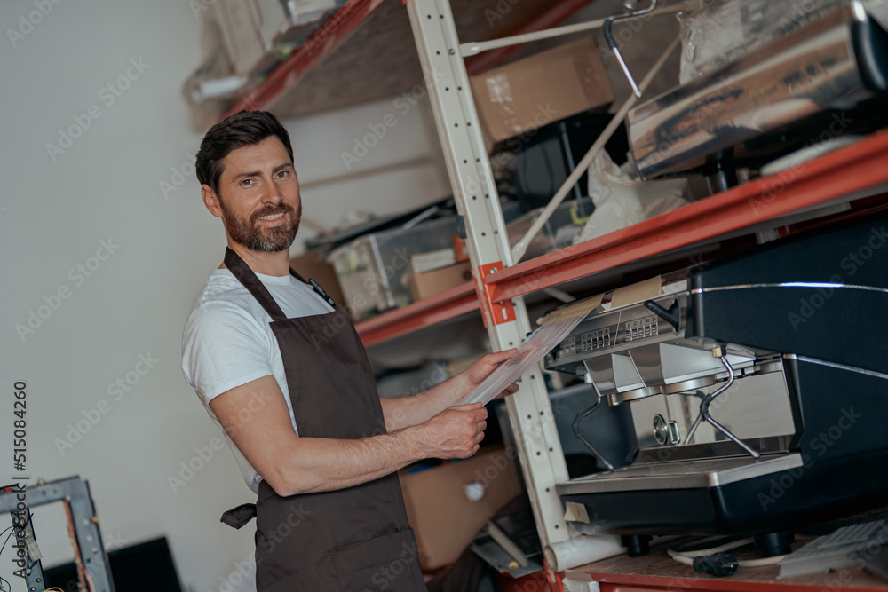 Business owner working on warehouse with different coffee machines Business owner working on warehouse with different coffee machines