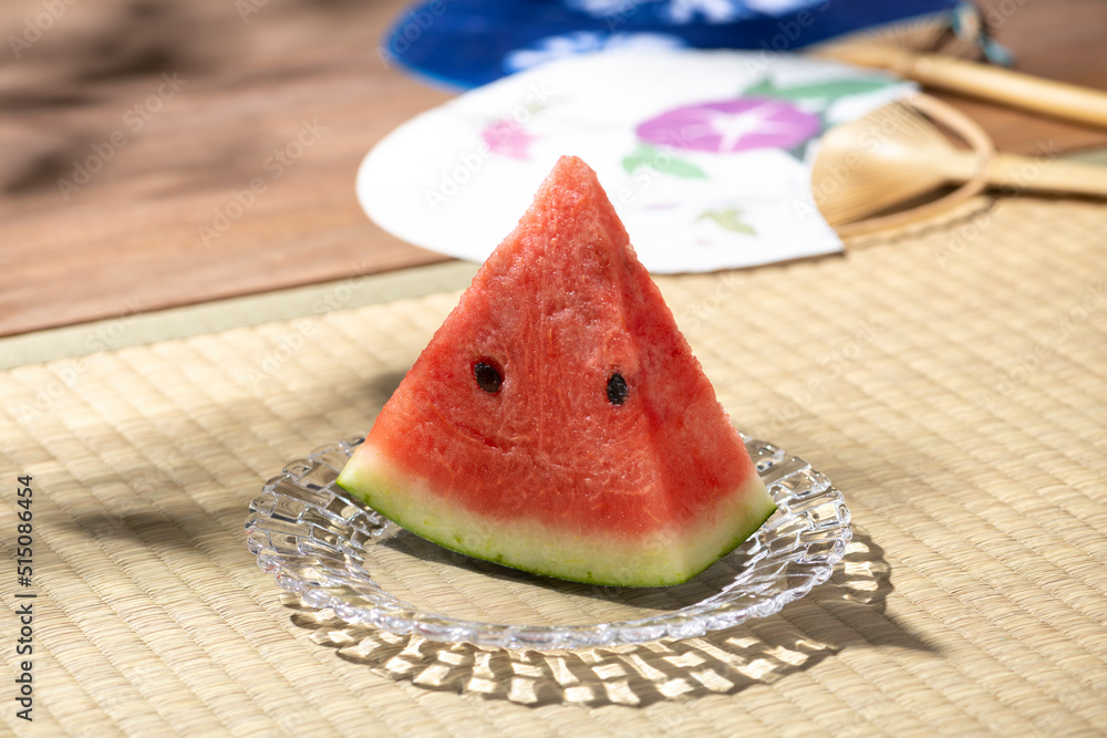 和室の畳の上にスイカとうちわ、日本の夏の風物詩 和室の畳の上にスイカとうちわ、日本の夏の風物詩