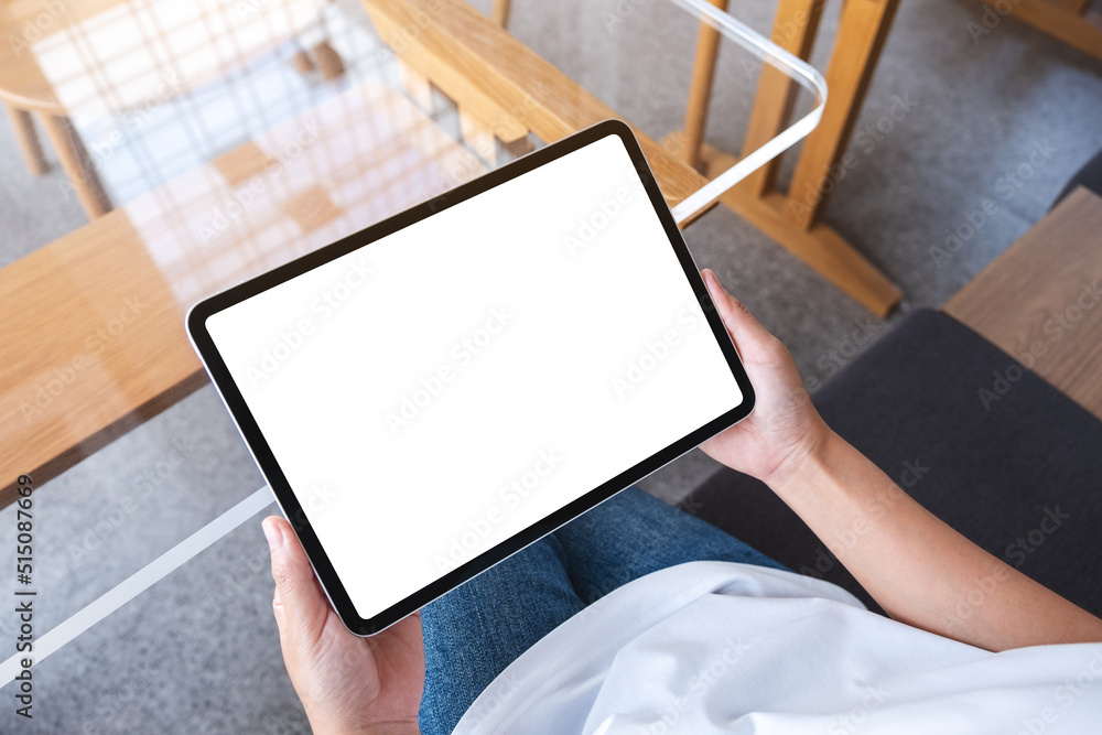 Top view mockup image of a woman holding digital tablet with blank white desktop screen in cafe Top view mockup image of a woman holding digital tablet with blank white desktop screen in cafe