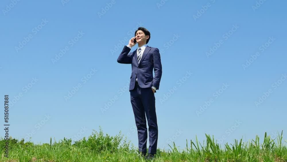 屋外でスマホで電話するビジネスマン 屋外でスマホで電話するビジネスマン
