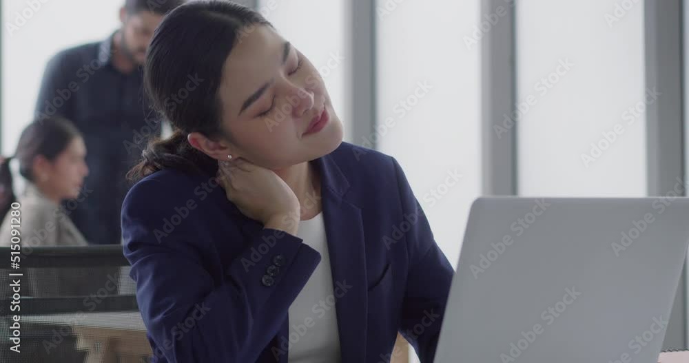 business woman stretch After sitting for hours at work. A young woman sits at a desk using a laptop to work. He works hard and is tired at the office. technology to help work concept business woman stretch After sitting for hours at work. A young woman sits at a desk using a laptop to work. He works hard and is tired at the office. technology to help work concept