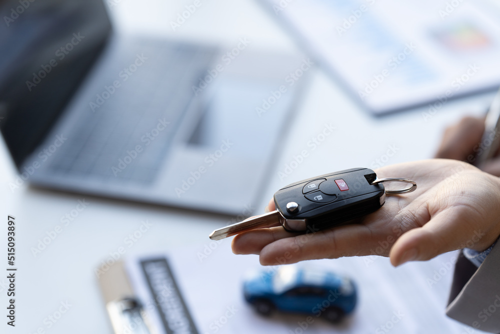 Obraz premium Car salesman gave the keys to the customers who signed the purchase contract legally, Successful completion of car sales, Purchase contract and key delivery.