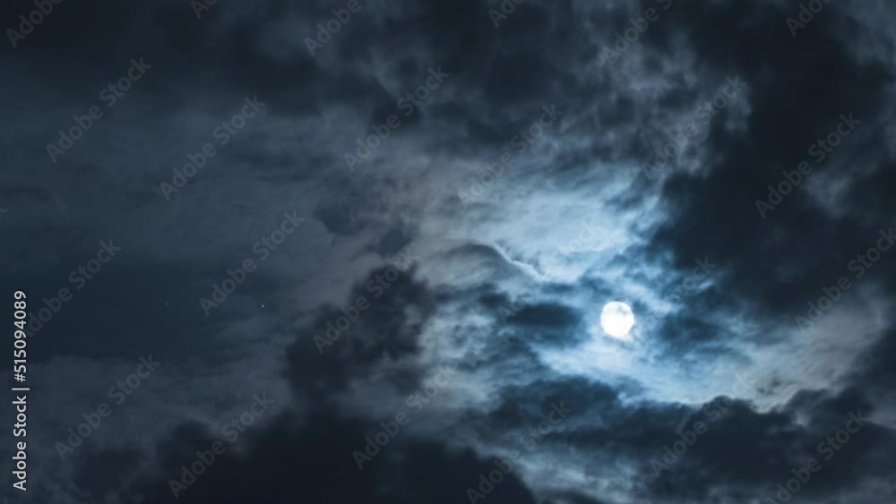 Full moon with black rays and clouds. Nighttime timelapse. Clouds floating through the bright disk of the moon. Smooth departure of the camera Full moon with black rays and clouds. Nighttime timelapse. Clouds floating through the bright disk of the moon. Smooth departure of the camera