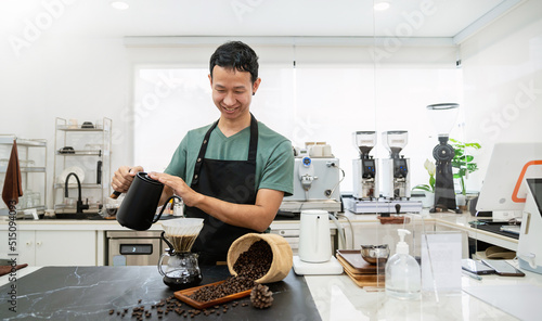 Startup successful small business owner sme handsome asian man drip hot water in to filter paper coffee slow bar in cafe. Portrait young man barista cafe owner SME entrepreneur blogger business banner
