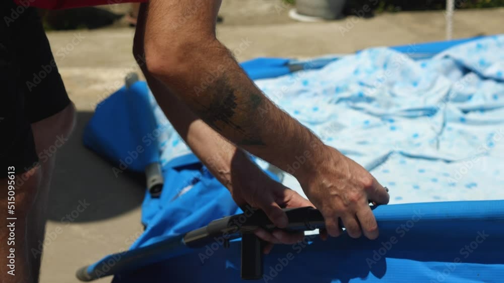 Man assembling metal base of frame pool Close-up of hands. Backyard pool installation. Summer season Man assembling metal base of frame pool Close-up of hands. Backyard pool installation. Summer season