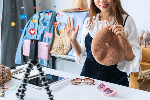 Fotografie Young Asian woman entrepreneur talking camera live recording video on social network at home