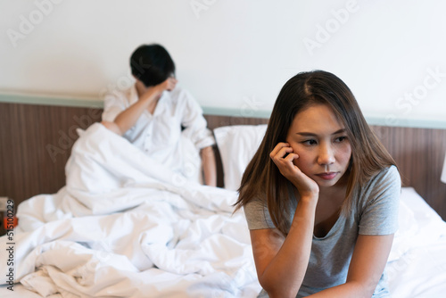 Young couple in quarrel sitting on bed at home. Upset lovers consider break up. Relationship breakdown, family relations, problems concept.