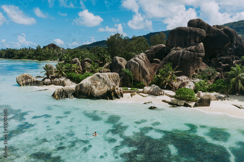 "La digue" island in Seychelles. Silver beach with granitic stone, and jungle. Man enjoying vacations and relaxing on the beach. Aerial view 