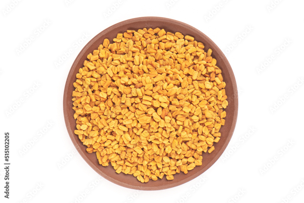 Fenugreek (Trigonella foenum-graecum) in clay plate on white background isolated. Macro. Flat lay. Indian cuisine, ayurveda, naturopathy concept Fenugreek (Trigonella foenum-graecum) in clay plate on white background isolated. Macro. Flat lay. Indian cuisine, ayurveda, naturopathy concept