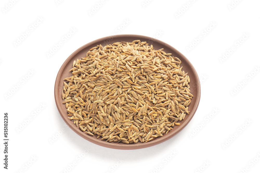 Spice cumin (jeera) in clay plate on white isolated. Vegetarian food concept Spice cumin (jeera) in clay plate on white isolated. Vegetarian food concept