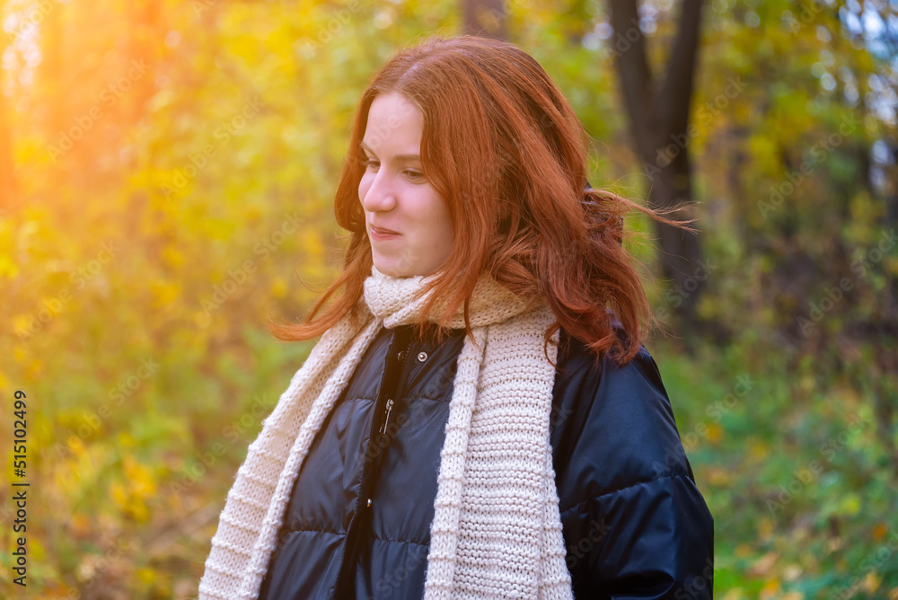 portrait of a red-haired smiling girl in a jacket and scarf against the background of autumn nature and bright sun concept of human emotion portrait of a red-haired smiling girl in a jacket and scarf against the background of autumn nature and bright sun concept of human emotion