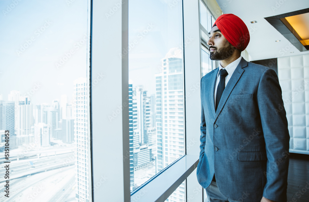 Fototapeta premium Indian businessman looking out the window in his office