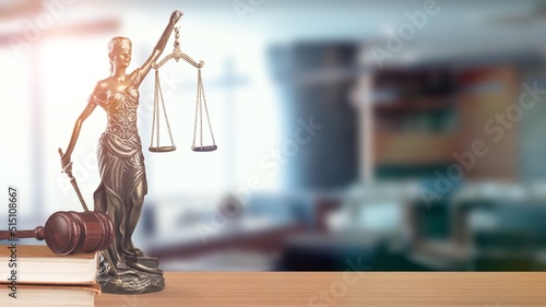 Legal and law concept. Statue of Lady Justice with scales of justice and wooden judge gavel on a table.
