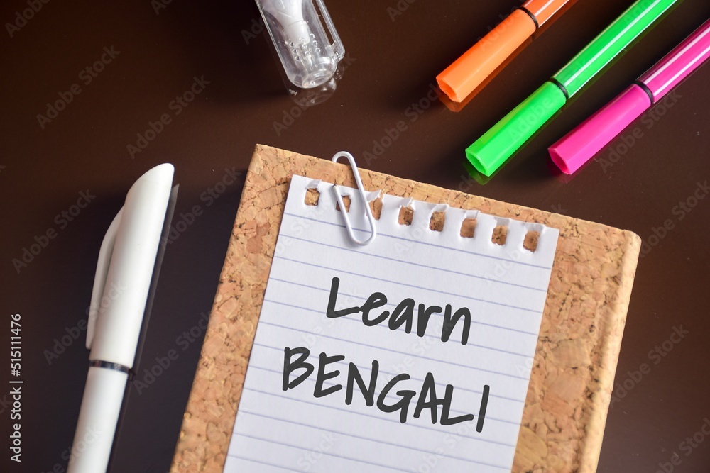 Learn Bengali text is shown on a piece of paper on study desk. Learning