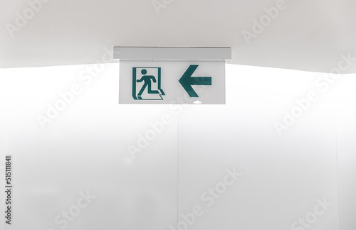 green exit sign on the white wall