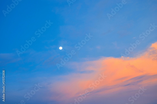 Vivid sky with fullmoon in sunset against blue sky background photo