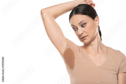 portrait of a beautiful surprised woman with sweaty armpits on a white studio background