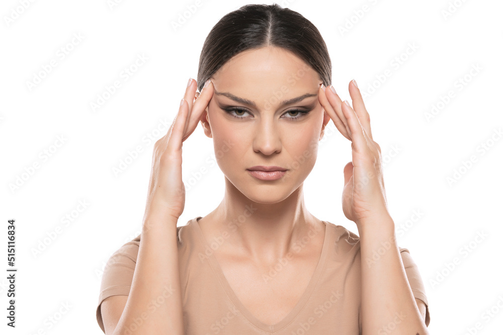 Young woman tightening her face skin with her fingers on a white background Young woman tightening her face skin with her fingers on a white background