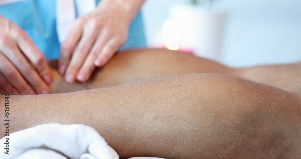 Masseuse doing sports massage of male lower leg Masseuse doing sports massage of male lower leg