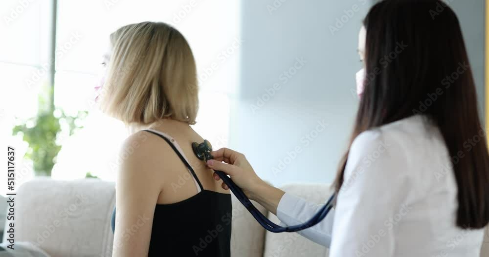 Professional pulmonologist examines young female patient with cough with stethoscope Professional pulmonologist examines young female patient with cough with stethoscope