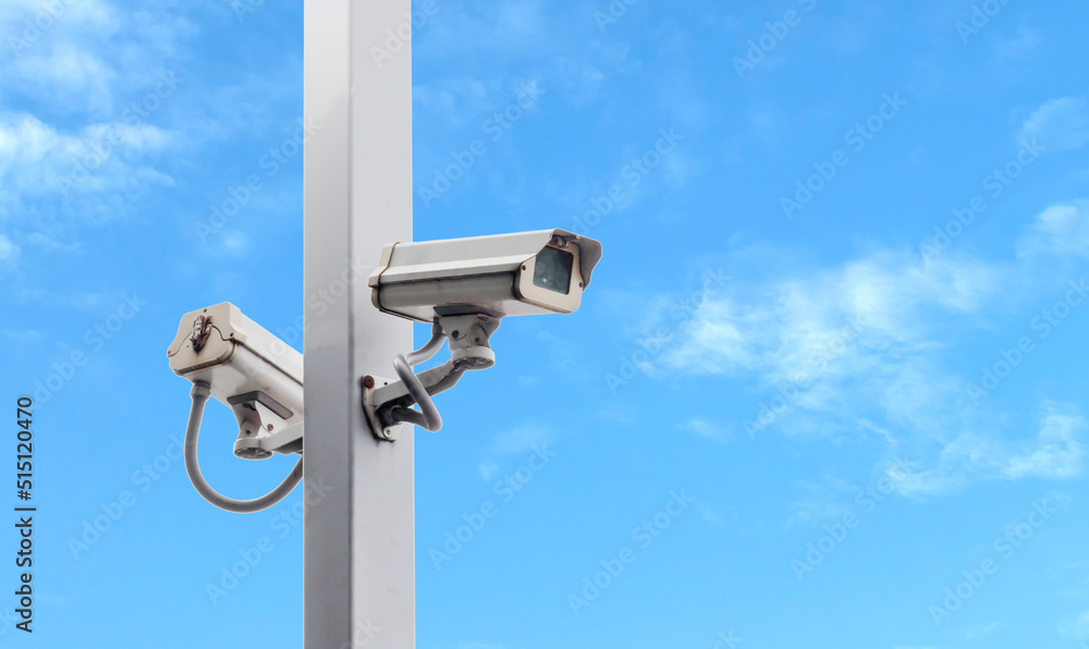 Outdoor white CCTV on pole with blue sky background and copy space Outdoor white CCTV on pole with blue sky background and copy space