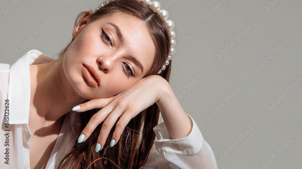 Fototapeta premium Beautiful young model poses with her head tilted back and her elbow resting on her knee. Active lifestyle.