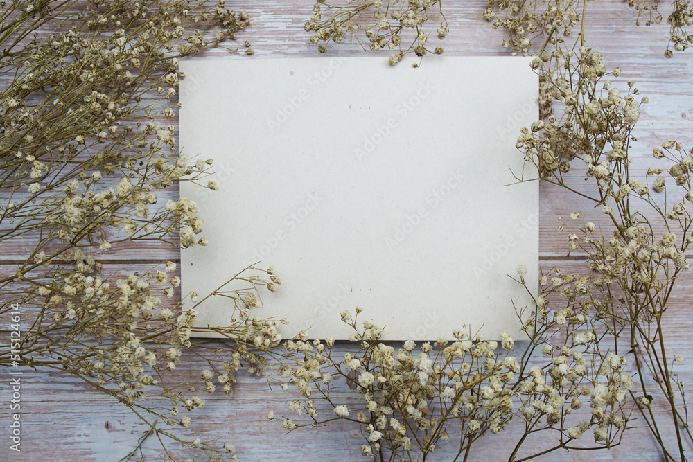 Empty card for text message and flower decoration on wooden background