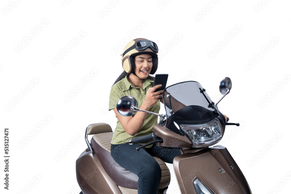 Asian woman with a helmet sitting on a scooter while using a mobile phone