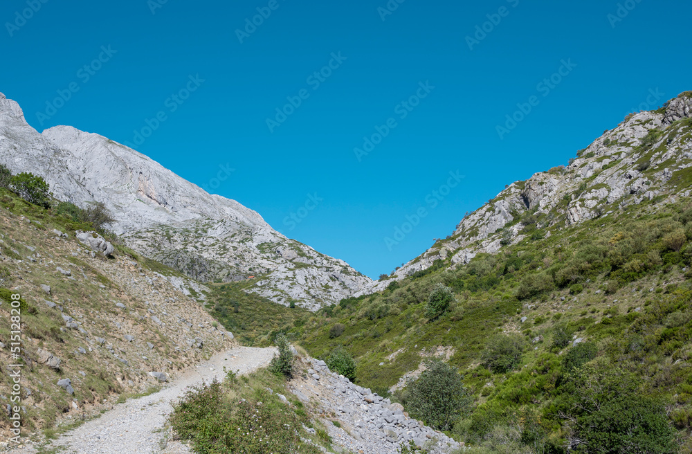 Camino de tierra entre montañas rocosas en el valle de Mazobre del parque natural de la montaña Palentina, España