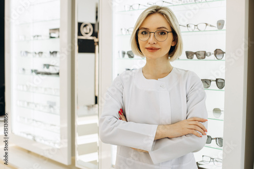 Female ophthalmologist at optical store helps to choose eyeglasses
