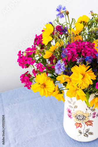 Beautiful summer bouquet of carnations, cornflowers and yellow chamomiles, part of home interior photo