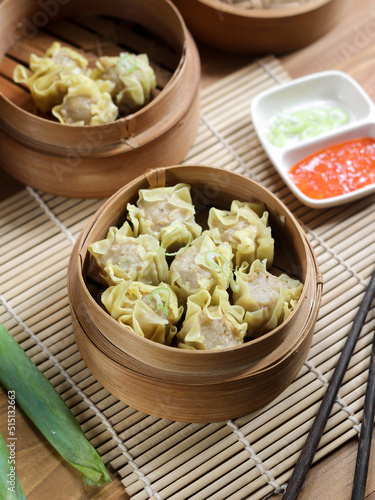 Siomay ayam, steamed dumpling dimsum with the main ingredients of chicken and shrimp. Served in traditional bamboo steamer on white background