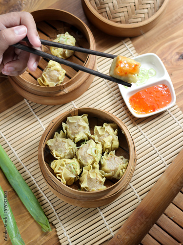 Siomay ayam, steamed dumpling dimsum with the main ingredients of chicken and shrimp. Served in traditional bamboo steamer on white background