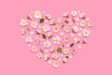 Rose flowers, leaves buds and petals in heart shape on pink background top view flat lay