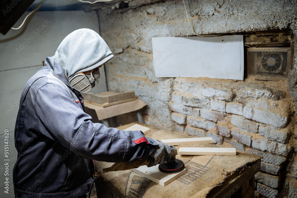 A joiner polishes the board. The process of processing boards in the carpentry workshop. Crafting.