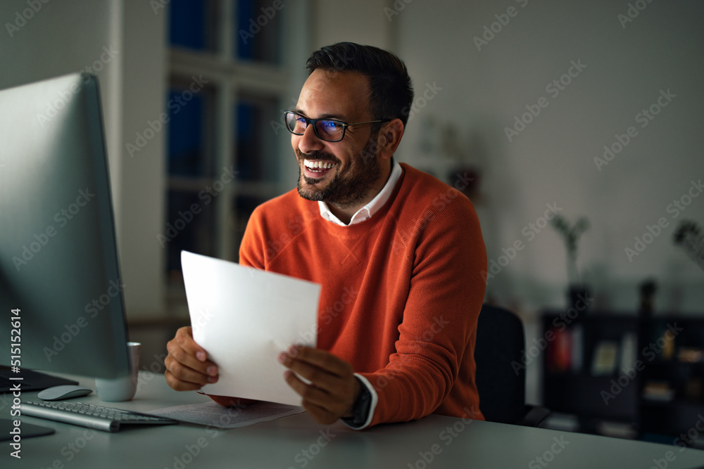 A smiling man working overtime, having a meeting online, holding A smiling man working overtime, having a meeting online, holding