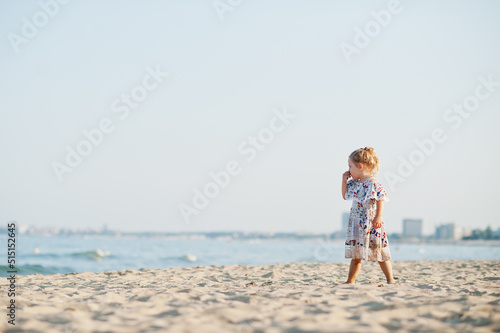 Daughter having fun on the beach. Portrait of happy cute little baby girl on vacation.