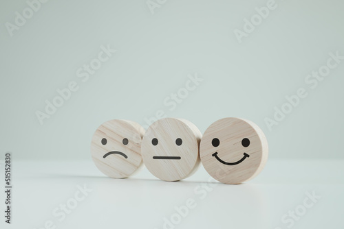 Customer service rating experience and feedback emotion and satisfaction survey concept. wood cube with smile, normal and sad face. Negative, neutral and positive facial expressions.